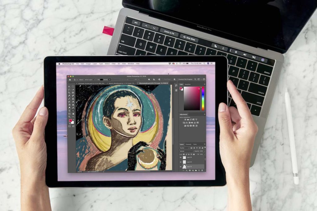 A person holds a tablet with a colorful digital drawing of a person. 