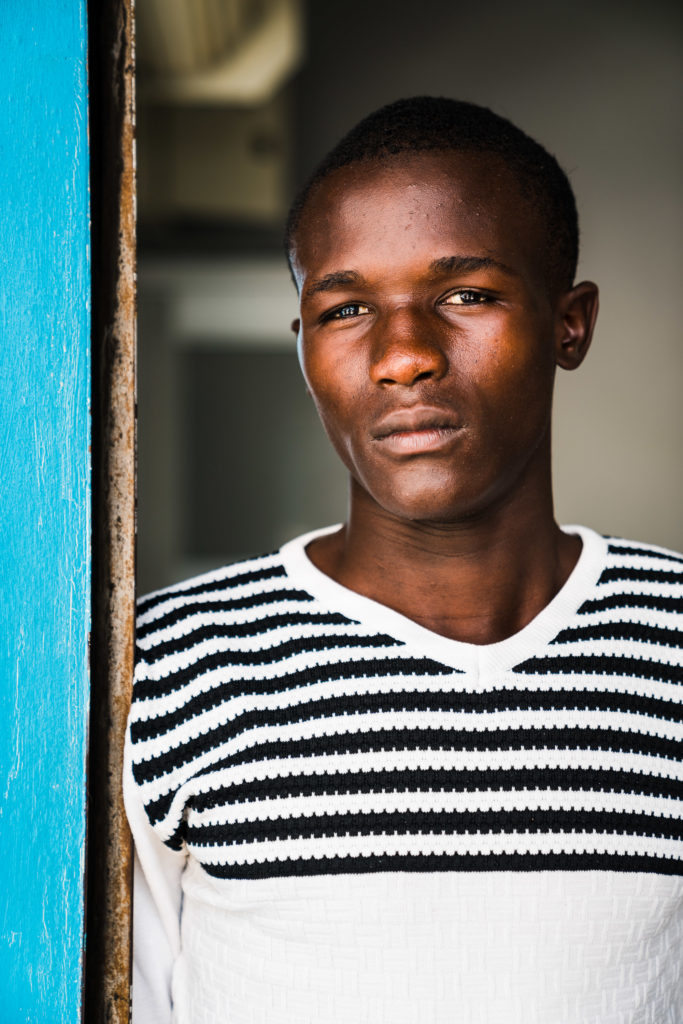 A man leans against a doorframe. 