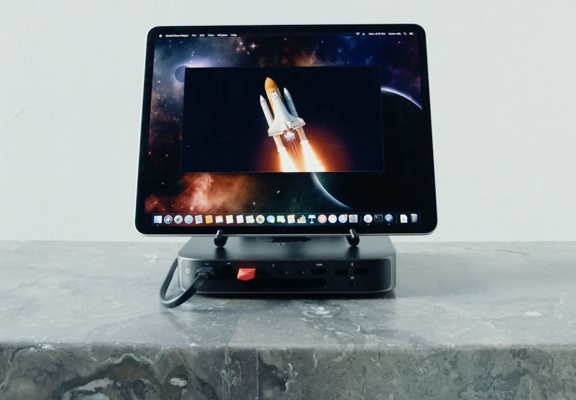 An iPad connected to a Mac mini displays a video of a rocket ship