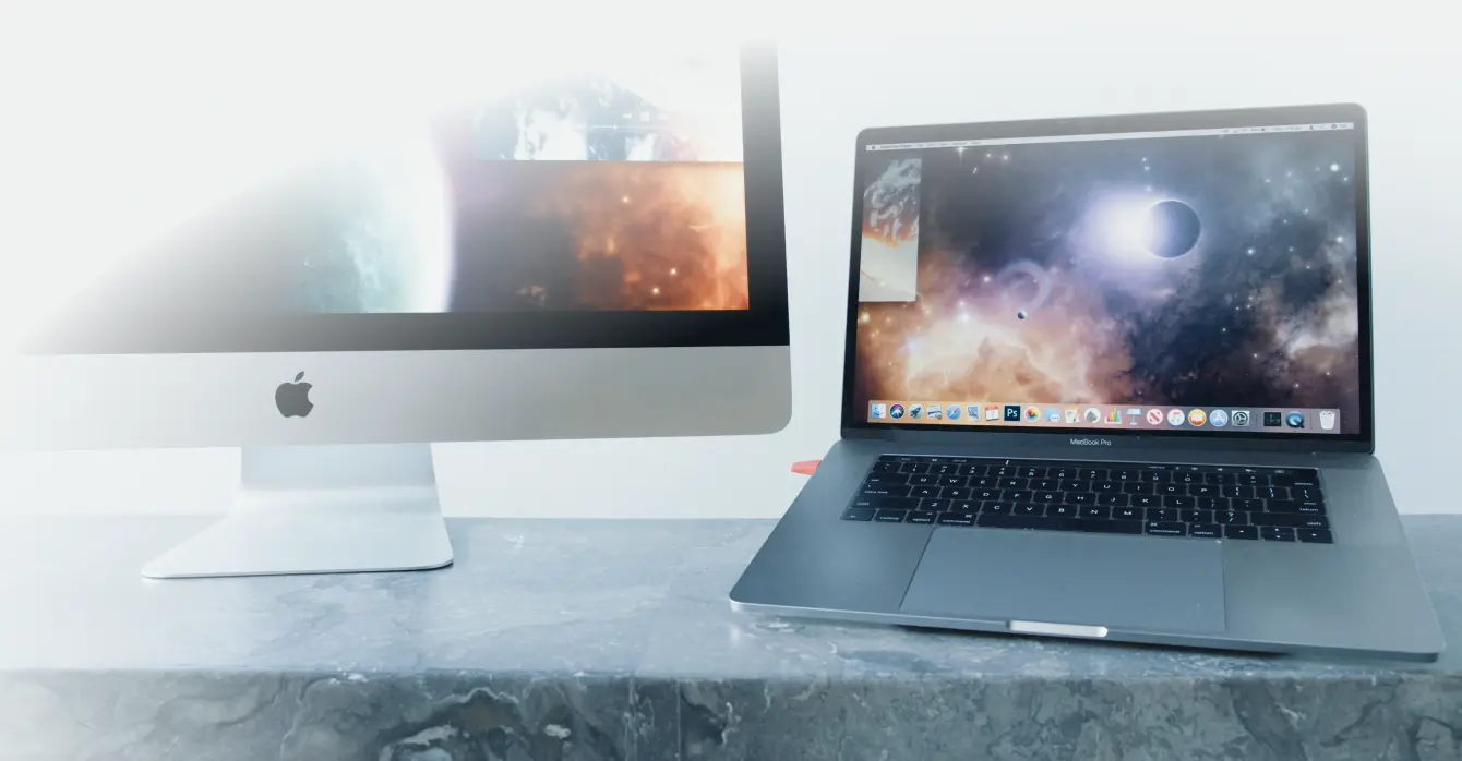 A Mac and iPad sit side by side on a desk