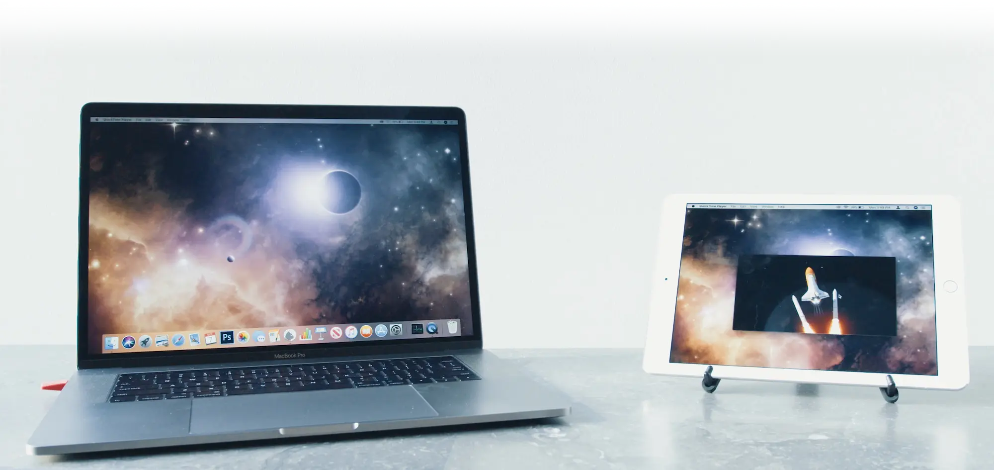 A Mac and iPad sit side by side on a desk