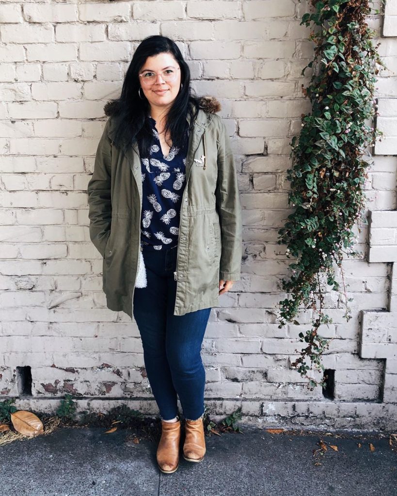 Rachel, our technical support manager, poses in front of a white wall. 
