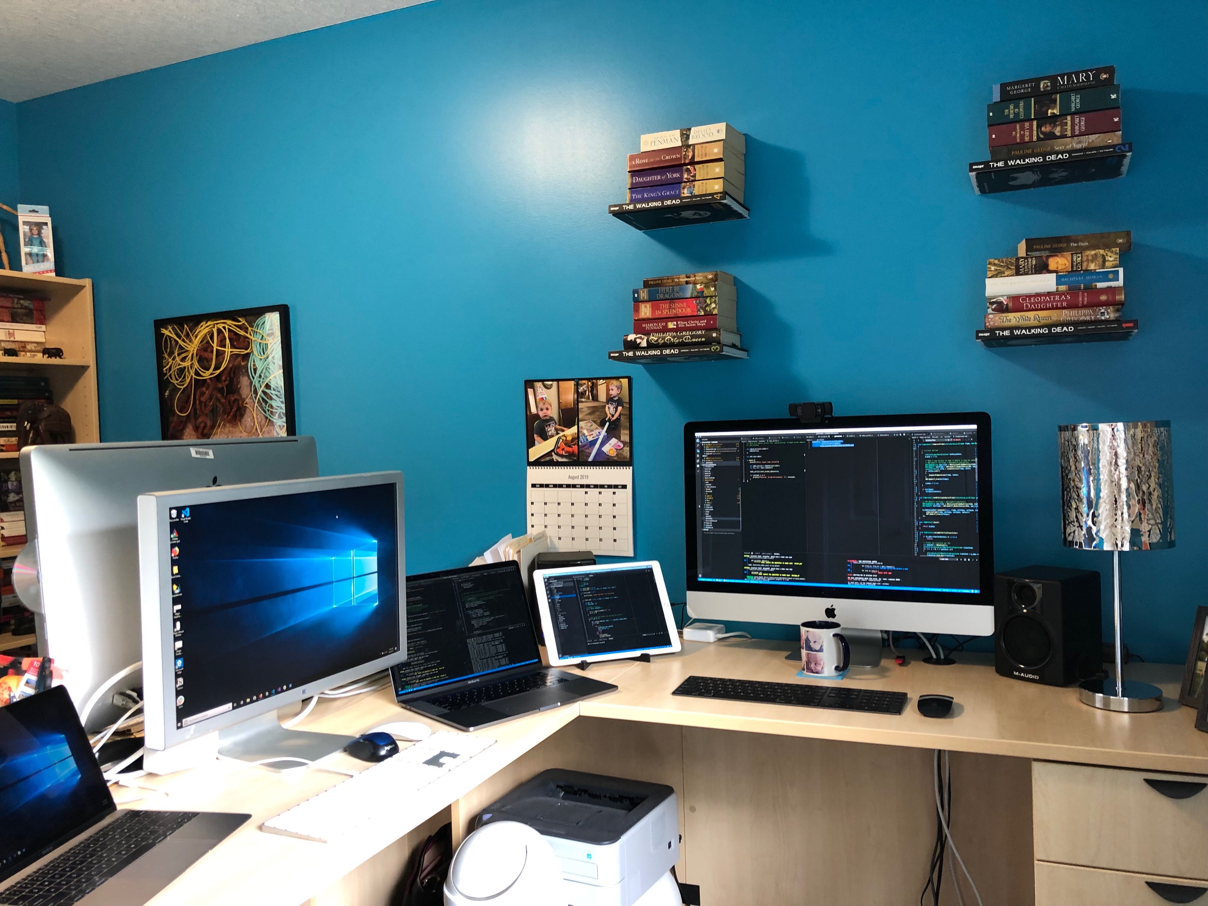 A modern hot office with many different computers and books hanging on the wall