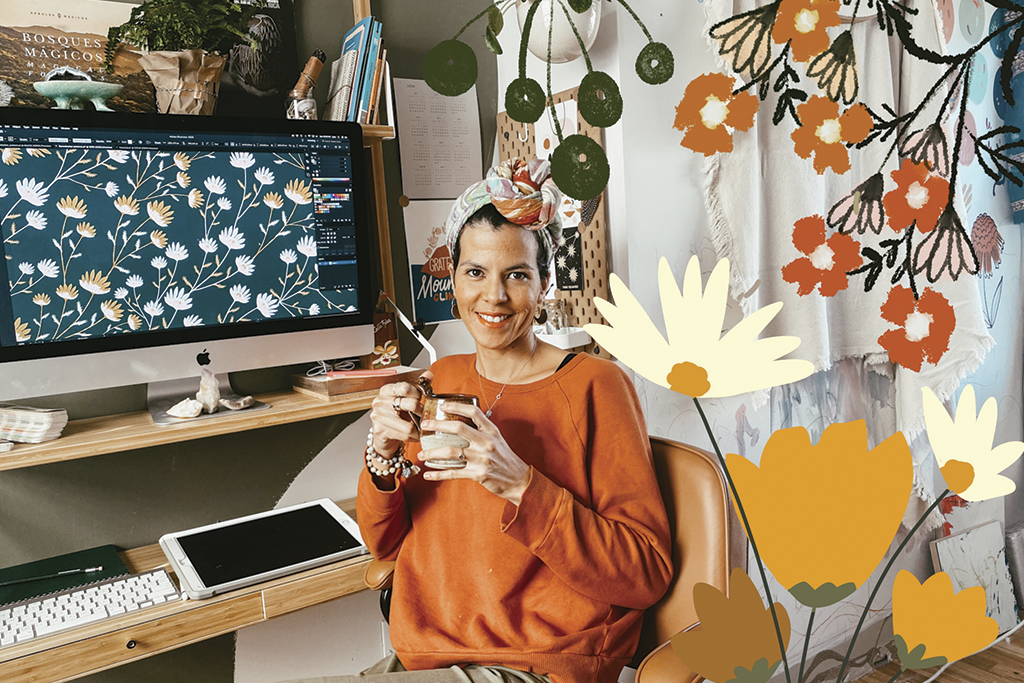 Dora sits in her bright office surrounded by drawings of flowers