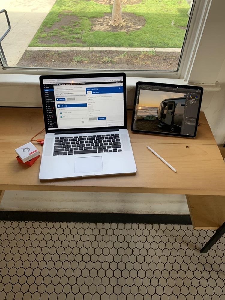 A laptop, tablet, and Luna Display sit on a table in an airstream. 