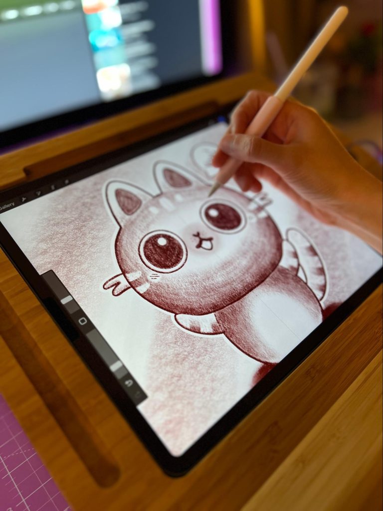 An artist draws a cat using the Procreate iPad app