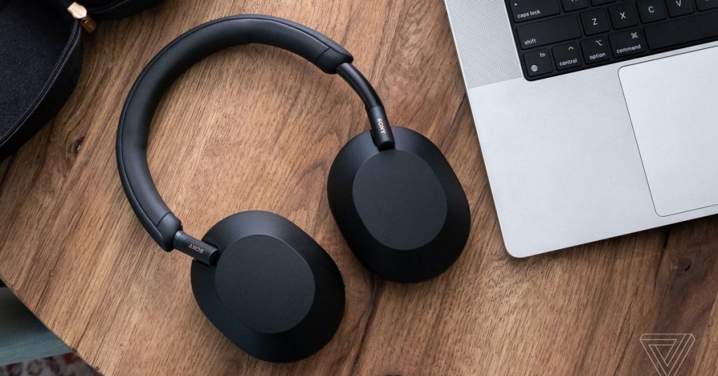 noise cancelling headphones laying next to a computer 