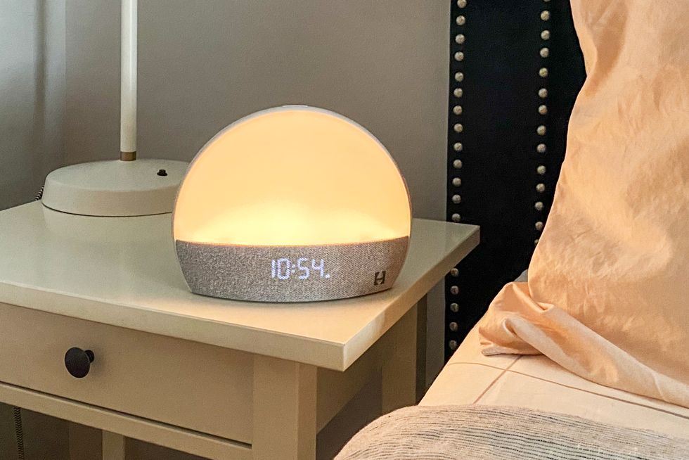 a hatch sunrise alarm clock sitting on a bedside table