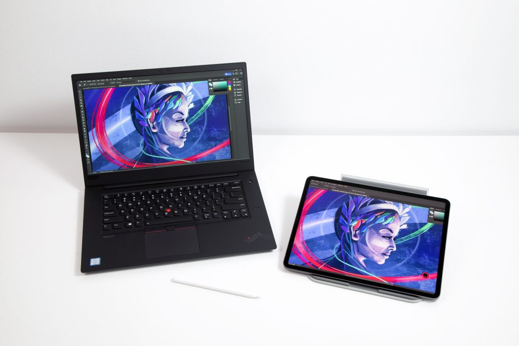 iPad and laptop side by side with the ipad mirroring the desktop screen. Photoshop is open on both screens with a drawing of a woman