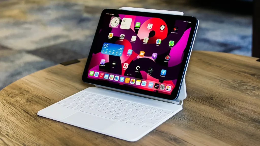 iPad sitting on table with magic keyboard and an Apple pencil connected to the top 