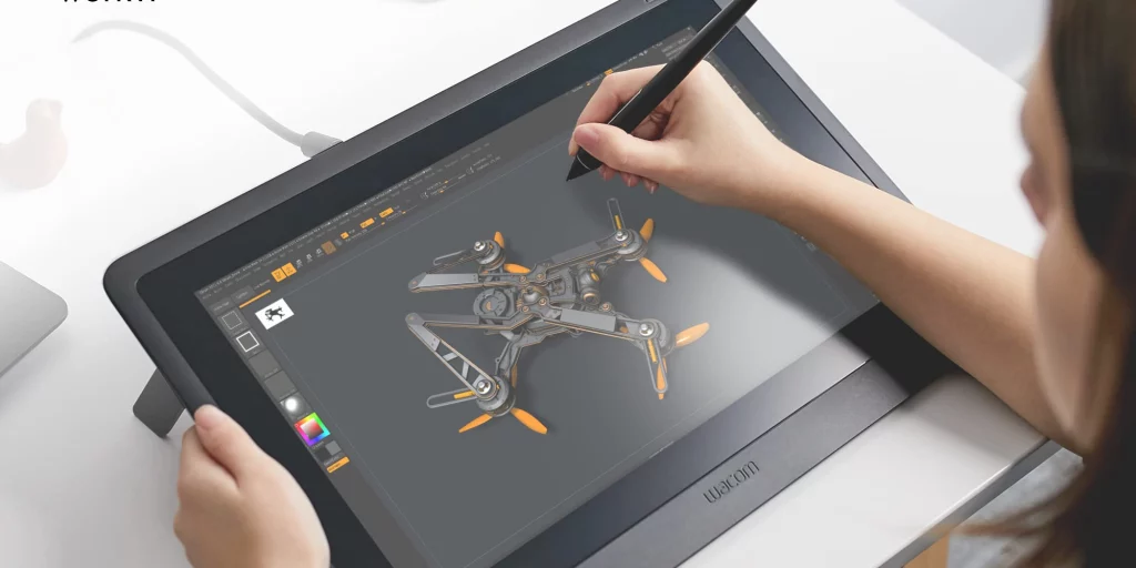 person drawing on a wacom pen display with a machine on the screen 