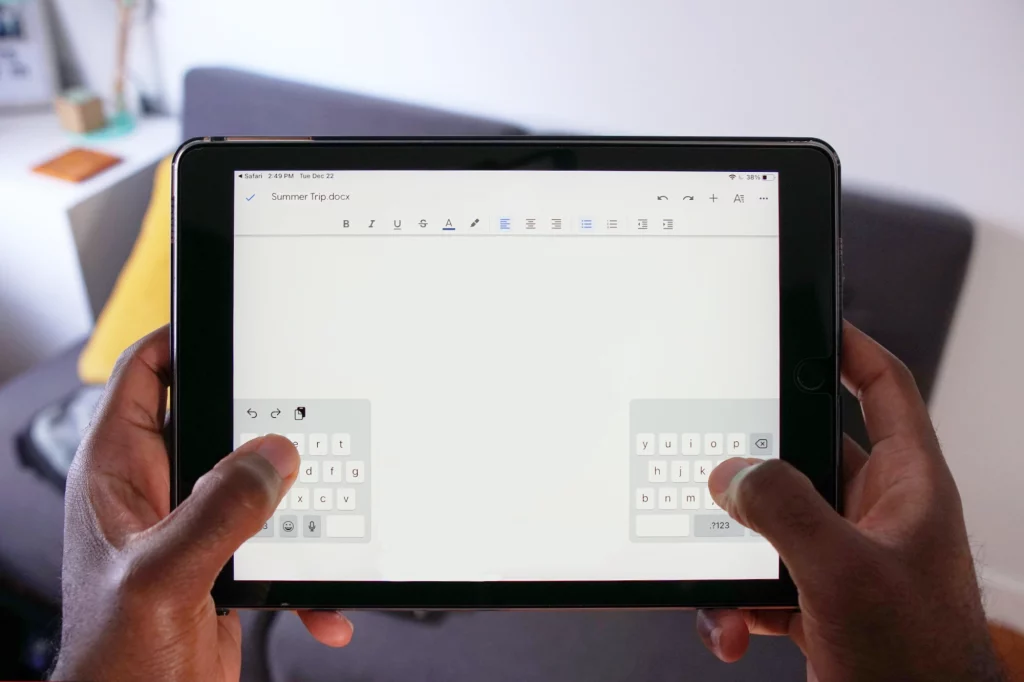 person holding an ipad with a split keyboard