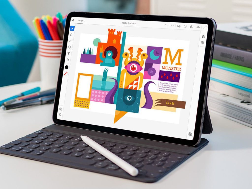 adobe illustrator app open on an iPad. the ipad is connected to a keyboard and has an Apple Pencil laying on top of it. 
